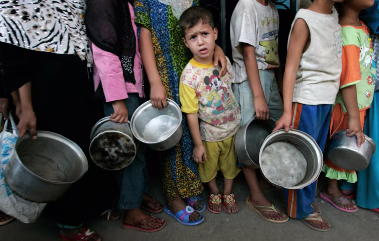 Poor residents wait in line to receive food during the fasting month of Ramadan at the Sunni mosque of Abdul Qadir al-Gailani in Baghdad