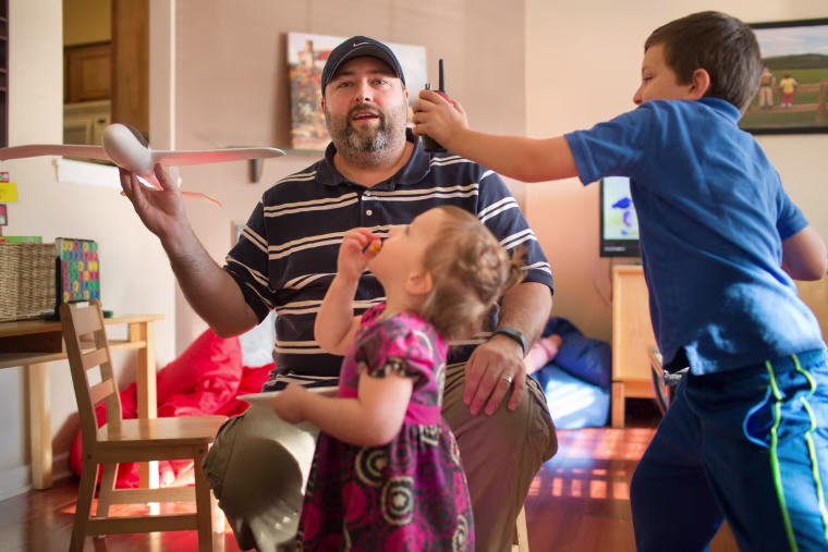 Image: Brad Chaffee plays with his children at home in Charlottesville, Va.