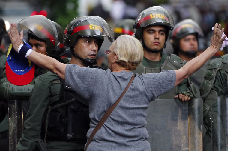 Image: An opposition supporter shouts at a riot police officer during a protest against President Nicolas Maduro's government in Caracas