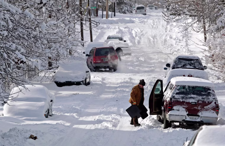 Image: A man clears snow from his car in Indianapolis, Ind.