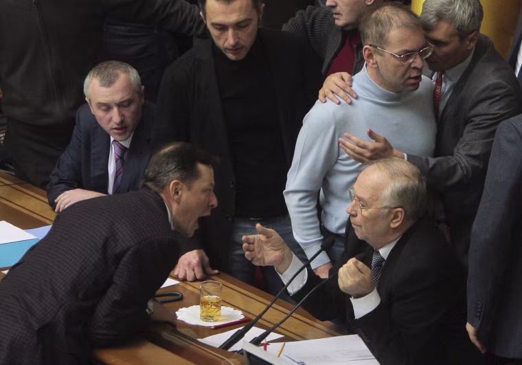 Image: Ukrainian deputies surround speaker Rybak during a session of parliament in Kiev