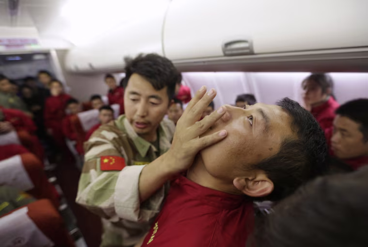 Image: An instructor pushes a student's jaw during a special course on flight safety on the outskirts of Beijing