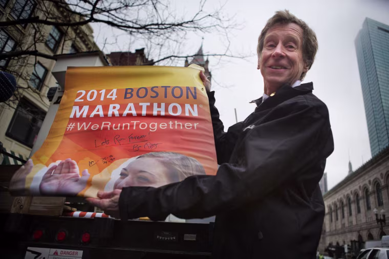 Former Boston Marathon winner Bill Rodgers holds a new banner for the Boston Marathon on March 20, 2014.