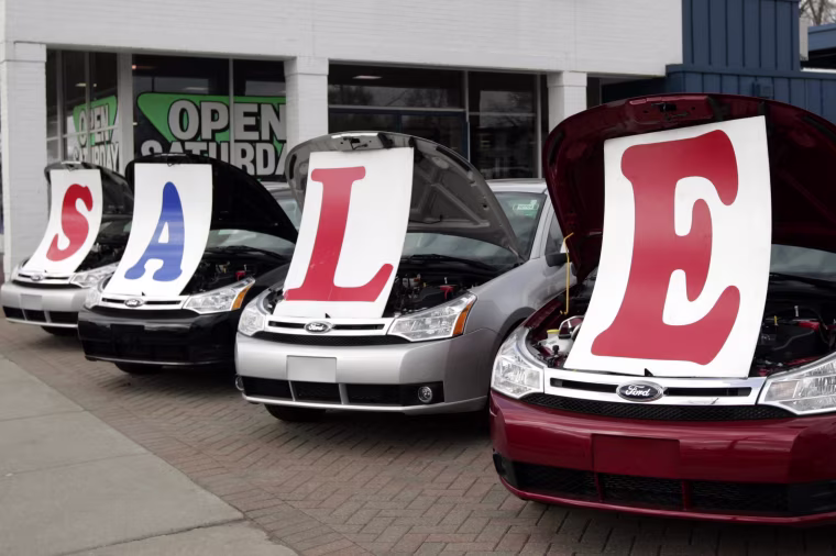 Image: Four 2009 Ford Focus vehicles sit with a 'Sale' sign under their hoods.