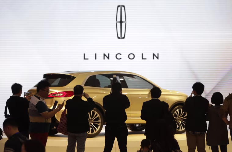 Visitors take photos of a Lincoln MKX SUV concept car at Auto China 2014 in Beijing