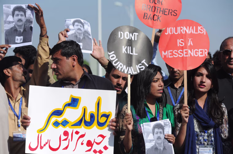 Image: Pakistani journalists hold placards and photographs bearing the image of colleague Hamid Mir