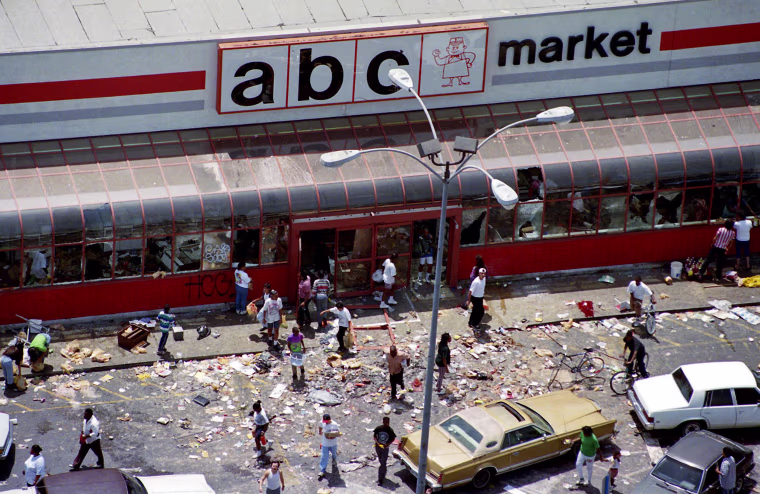 Looters mill in the parking lot of the ABC Market in South-Central Los Angeles as violence and looting ensued on the first day of riots following the verdicts in the Rodney King assault case, on April 30, 1992.