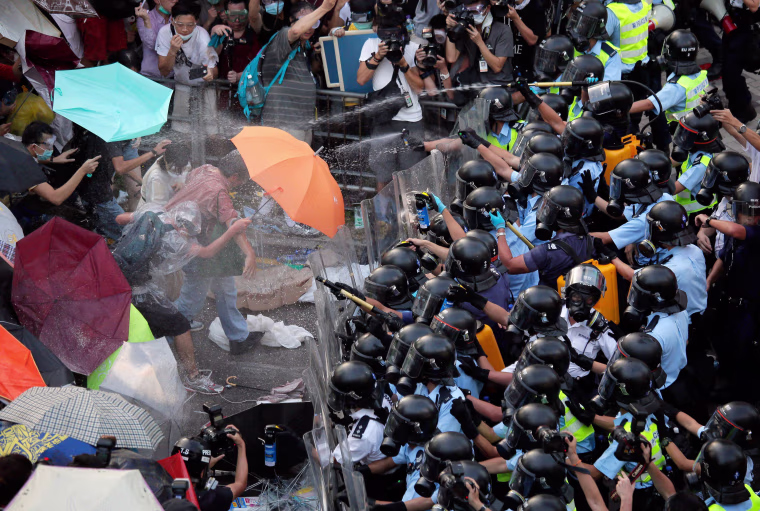 Image: Riot police use pepper spray against protesters