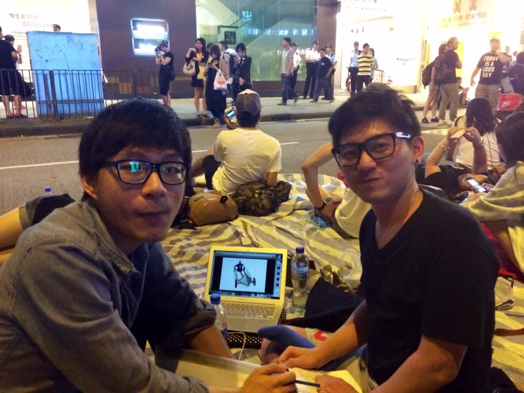 Sophomores Peter Chung, left, and Hugo Chan, both 21, work on a project for their Visual Communications course while taking part in the protests in Hong Kong.