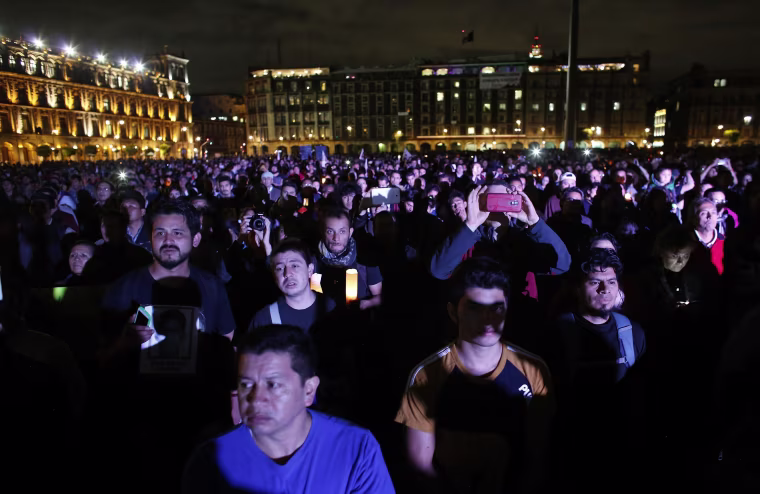 Image: Demonstrators listen to a speech delivered by the father of one of the 43 missing students of the Ayotzinapa teachers' training college, during a protest at Zocalo square in Mexico City