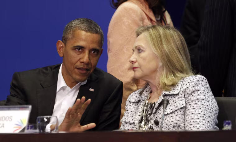 Image: U.S. President Barack Obama and Secretary of State Hillary Clinton talk during the plenary session of the Summit of the Americas in Cartagena