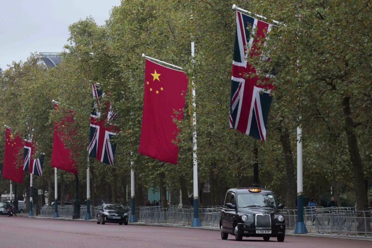 Image: A taxi drives past Chinese and British flags on the Mall in London