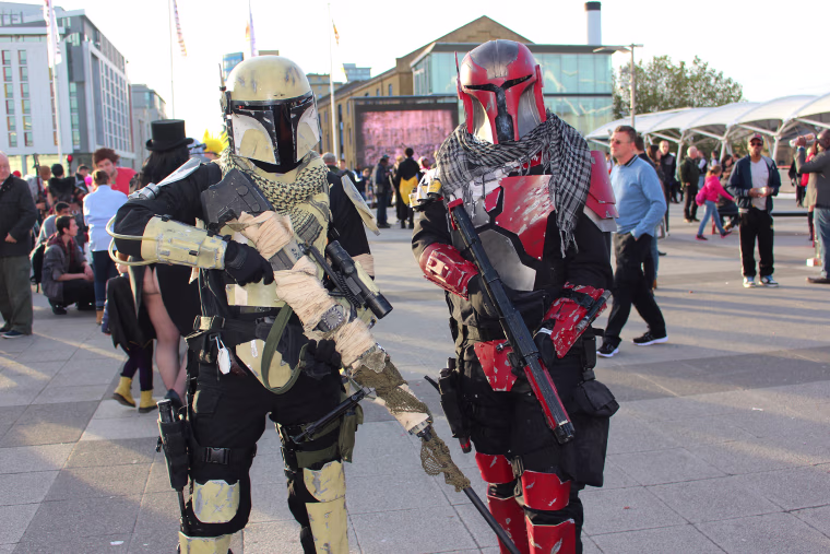 Attendees dressed as "Star Wars" characters pose with fake weapons outside the MCM Comic Con in London this weekend.