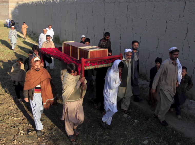 Image: Afghan men carry a coffin of an earthquake victim for burial in Nangarhar province, Afghanistan