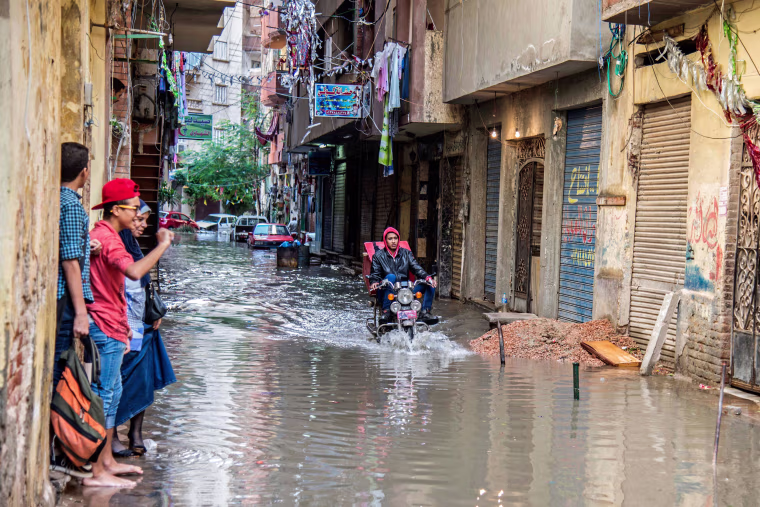 Image: A motorcyclist rides through floodwater