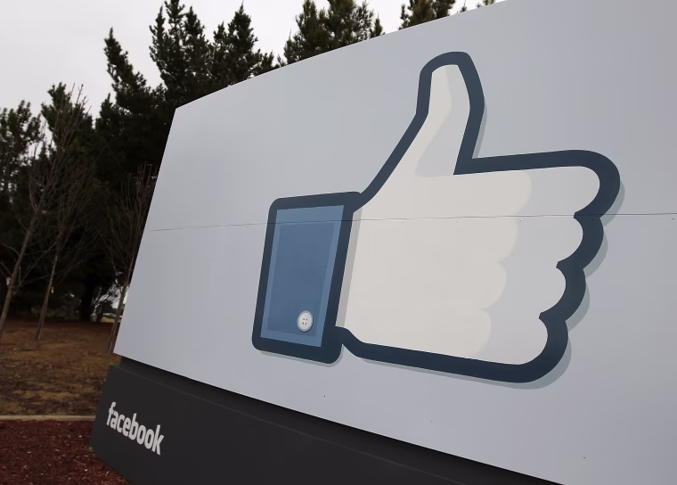 Image: A sign with the "like" symbol stands in front of the Facebook headquarters