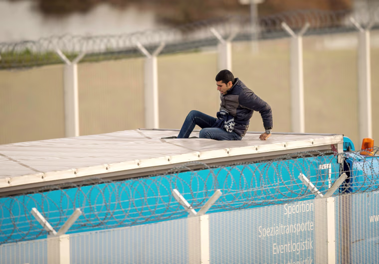 Image: A migrant or refugee enters the trailer of a truck