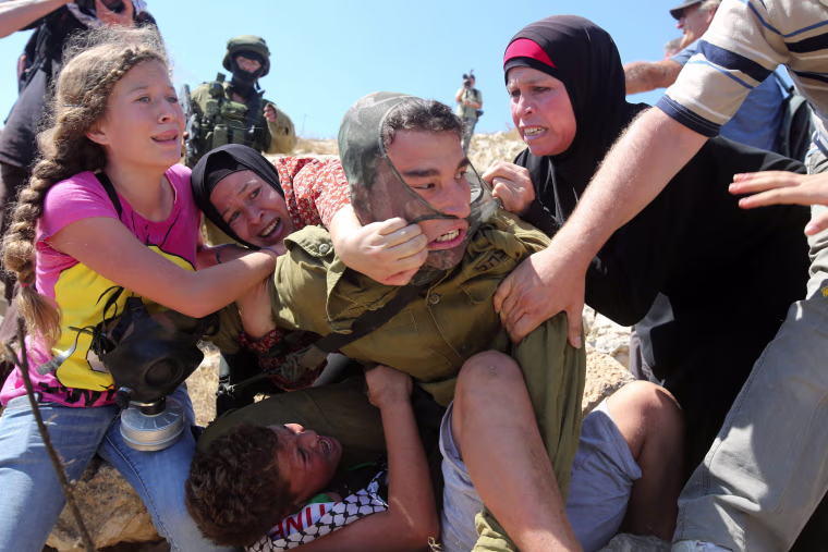 Image: Palestinians fight to free a Palestinian boy held by an Israeli soldier