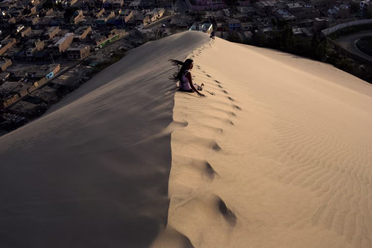 Image: A woman waits for a friend while climbing the Cerro de Saraja