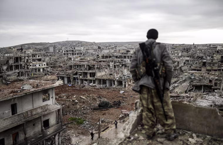 Image: Musa, a 25-year-old Kurdish marksman, stands atop a building