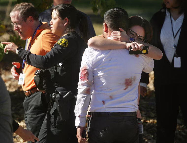 Image: A couple embraces following a shooting that killed multiple people