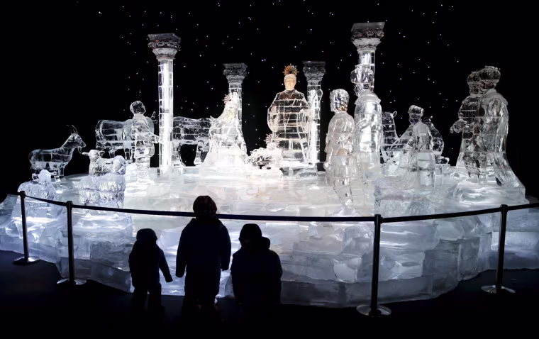 Image: Children stand in front of a nativity scene made entirely of ice, part of the ICE! event at Maryland's National Harbor just outside of Washington