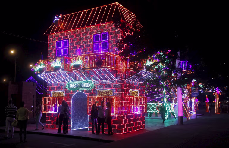 Image: People take pictures near illuminated Christmas decorations on a street in Medellin