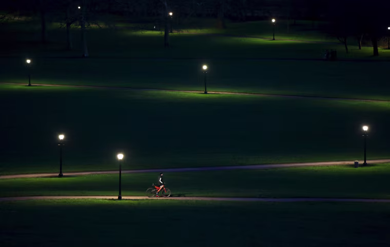Image: A cyclist rides through Primrose Hill in the early evening in London