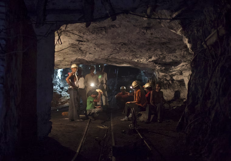 Image: File photo of miners resting inside an underground Barora coal mine at Dhanbad district