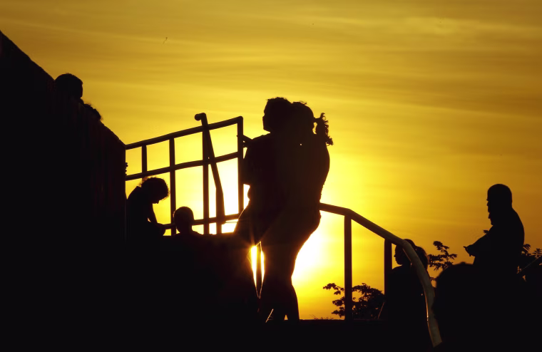 Image: Cubans migrants chat as the sun sets in the town of La Cruz