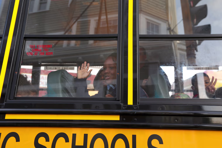 Image: A young student waves good bye to a parent