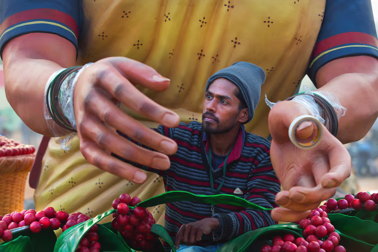 Image: An Indian worker paints the hand of a huge clay model of a tribal woman
