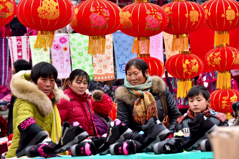 Image: People shop at a new year market ahead of the upcoming Spring Festival in Zaozhuang