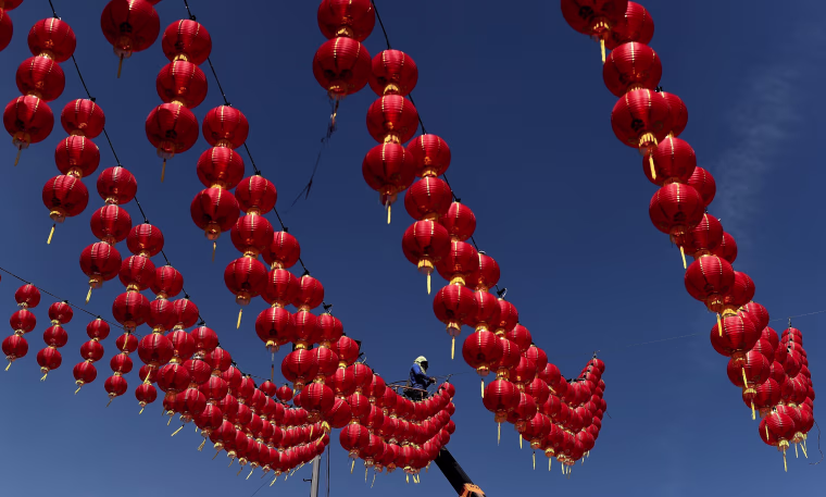 Image: A Malaysian worker puts up traditional Chinese lanterns
