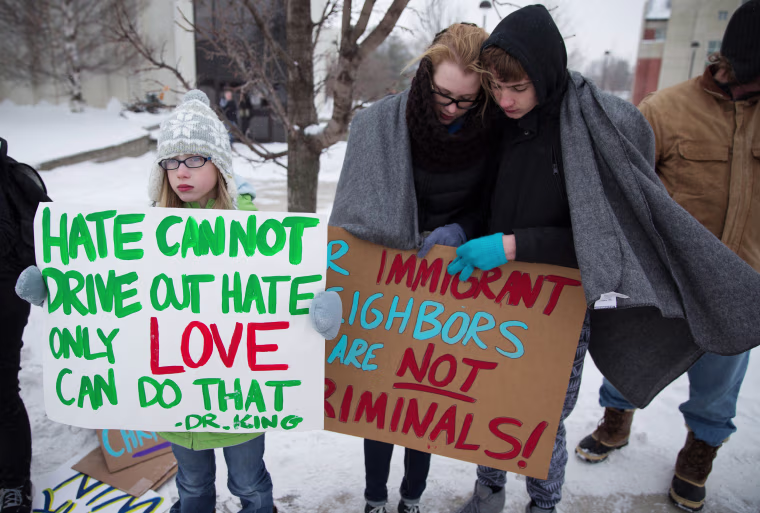 Image: People protest outside a Trump campaign rally in Iowa