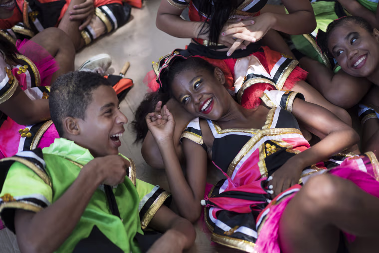 Image: Young revelers joke with each other as they lay on the shade during the \"Burial of the Mosquito\" carnival
