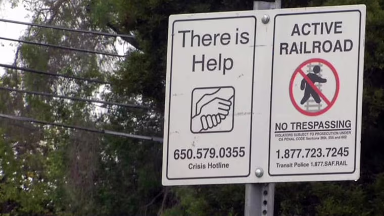 A "No Trespassing" sign is posted next to the local "Crisis Hotline" telephone number along Caltrain tracks in Palo Alto in this file photo.