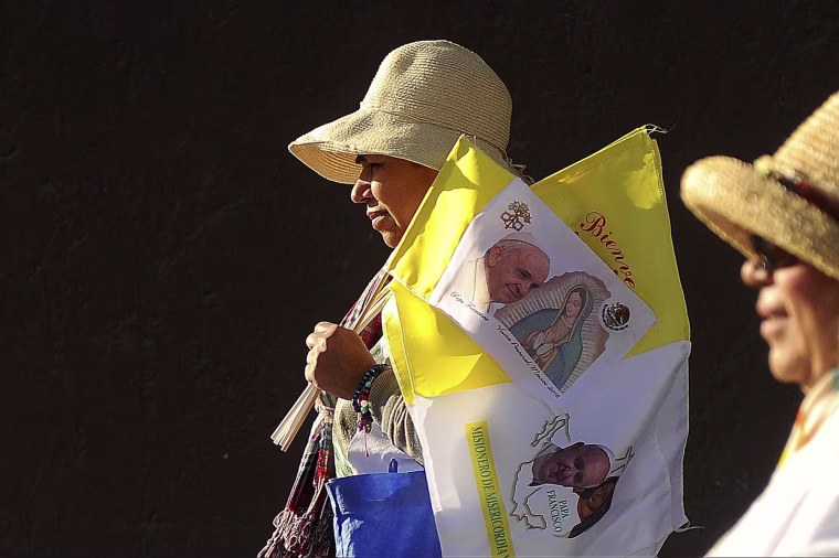 Image: Carrying souvenirs, Gloria LeJeune, from Arlington, Texas, walks with her sisters and a friend to attend a mass with Pope Francis in Ciudad Juarez