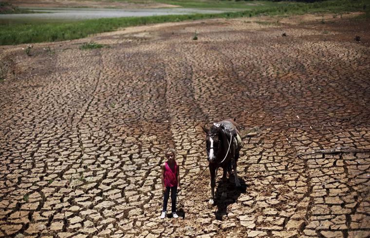 Image: Paula poses with her horse on the cracked ground of Atibainha dam
