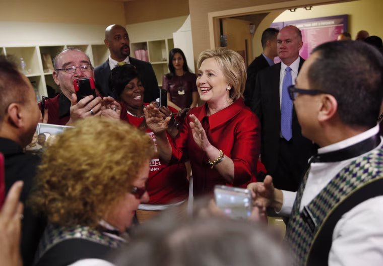Image: Clinton reacts as employees of Harrah's Las Vegas surround her during a visit