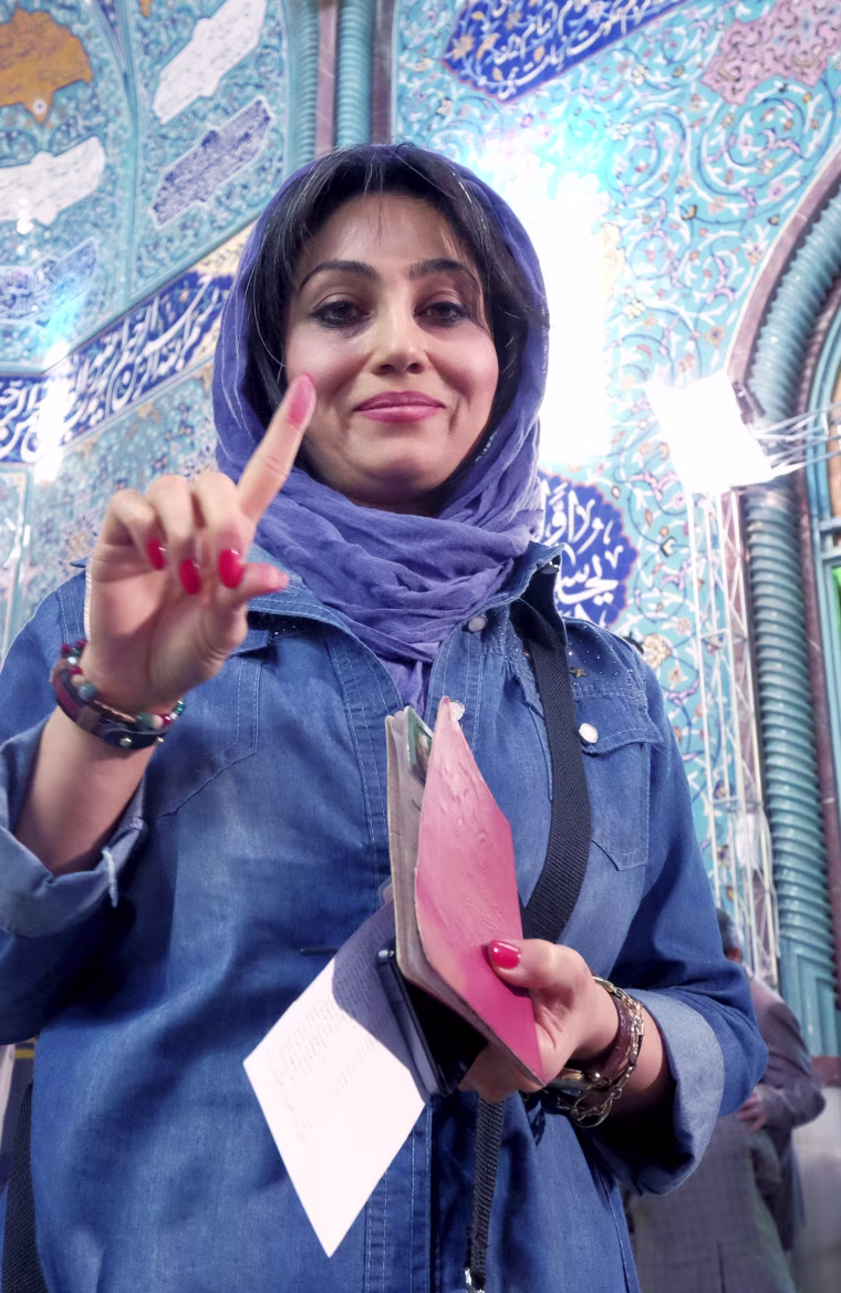 Image: Iranian woman shows her ink-stained finger after voting