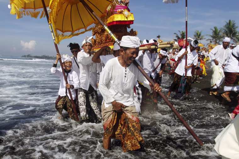 Image: Balinese Hindus carry Pratimas, or symbols of God, on the beach during Melasti, a purification ceremony, ahead of the holy day of Nyepi, in Gianyar