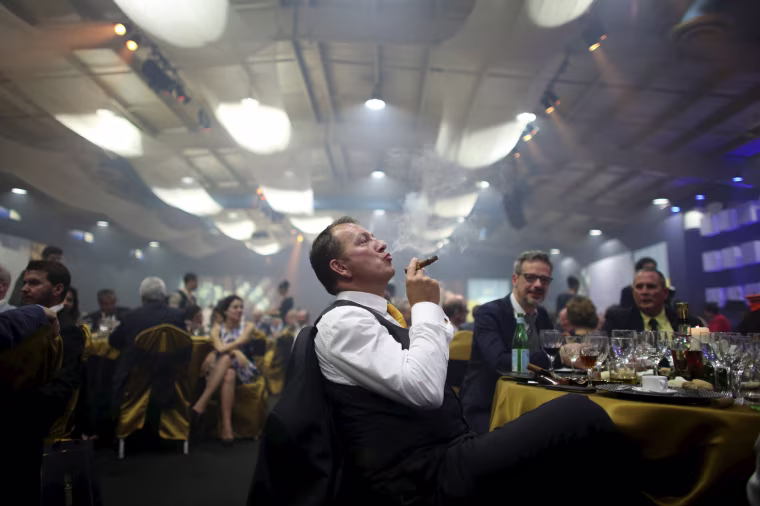 Image: Juan Philippe from France enjoys a cigar during the gala dinner of the closing of the XVIII Habanos Festival in Havana