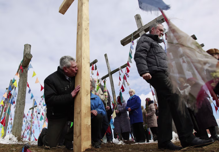 Image: A Belarussian Catholic believer kisses a wooden cross during a procession