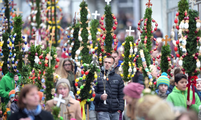 Image: People carry homemade palms through the downtown Bad Saulgau