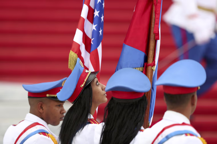 Image: Honor guards carry the U.S. and Cuban flags as they stand at the bottom of the stairs of the Revolution Palace during a visit by U.S. President Barack Obama in Havana