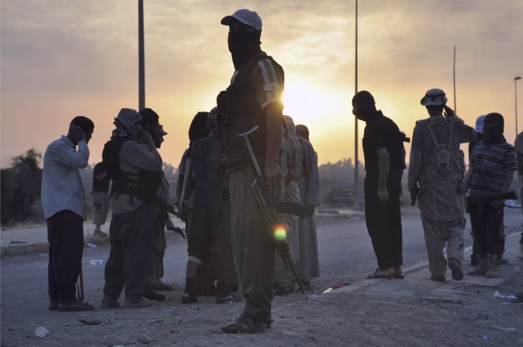 Image: Fighters of the Islamic State of Iraq and the Levant (ISIL) stand guard at a checkpoint in the northern Iraq city of Mosul