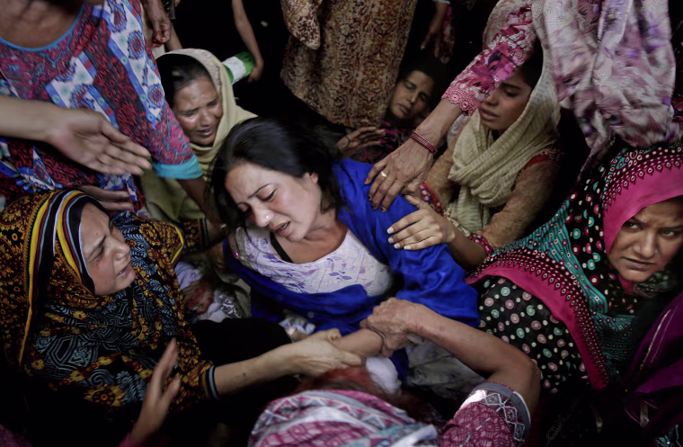 Image: Women try to comfort a mother who lost her son in bomb attack in Lahore
