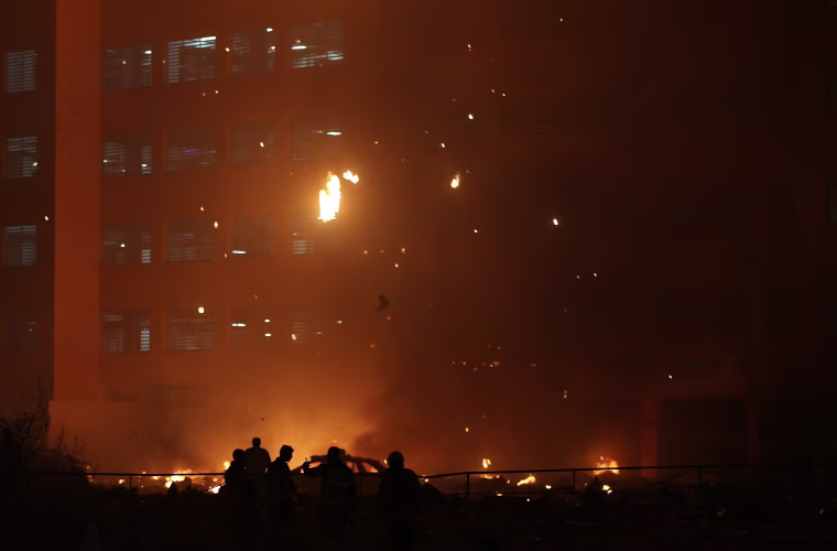 Image: Debris falls from a high-rise building as a fire spreads up the side of the building in Ajman