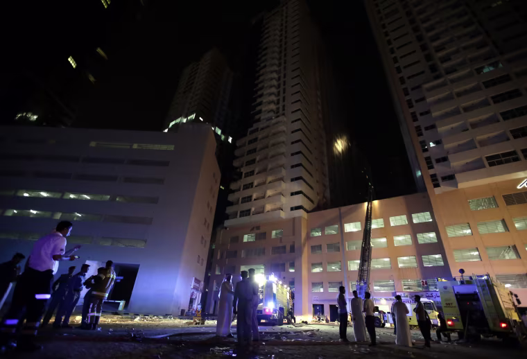Image: Members of the Civil Defense and fire services extinguish a fire at residential buildings